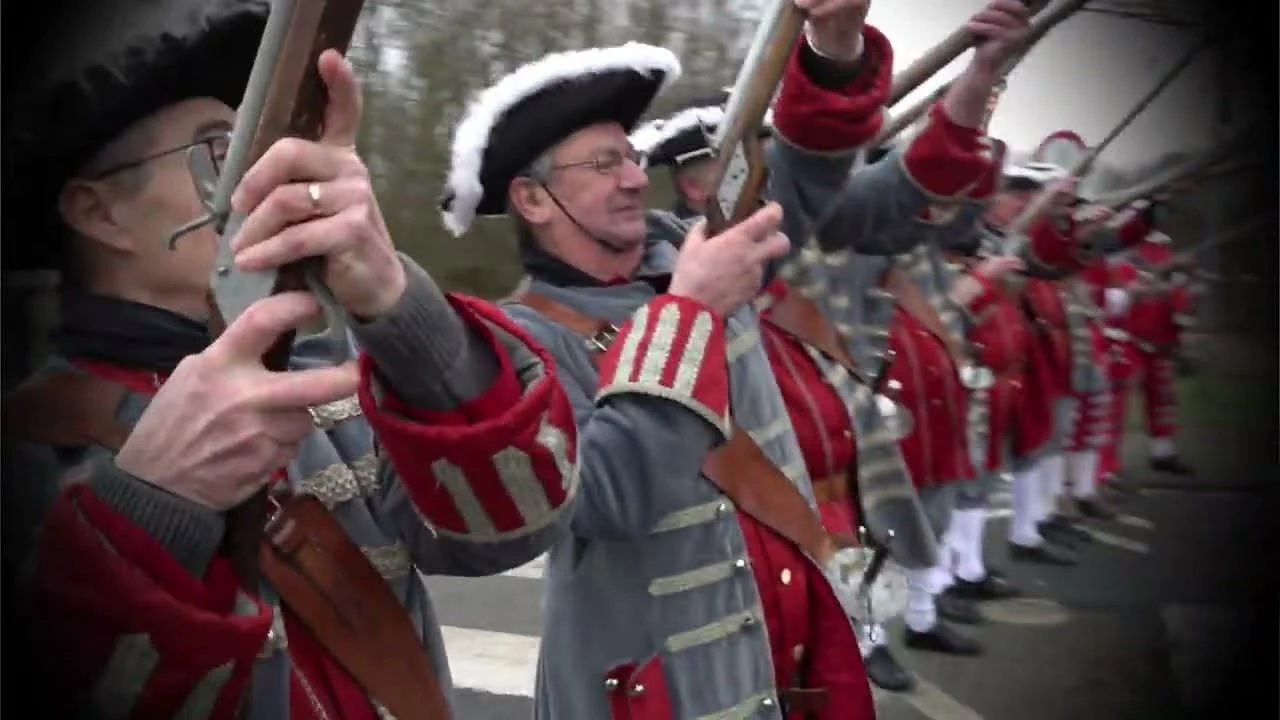 Reconstitution militaire en costume d'époque, mousquets levés
